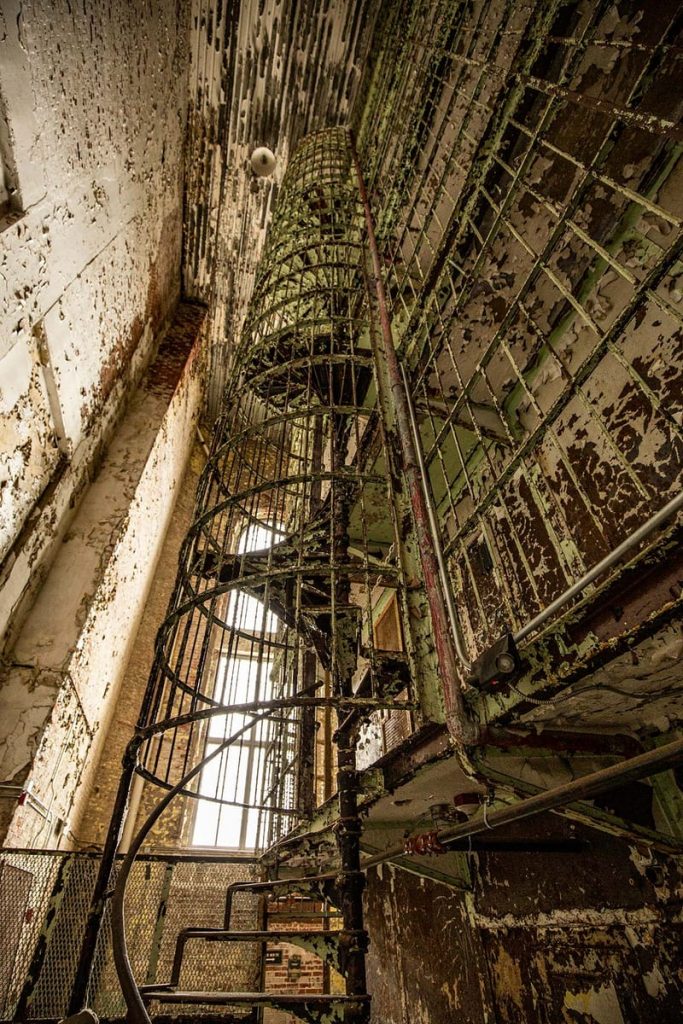 A shockingly elegant spiral staircase at the end of a cellblock