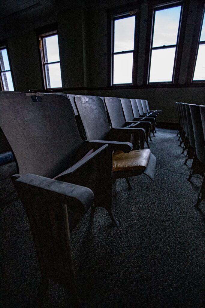 Dusty theater chairs remain from days of use in the theater, now the shuffling sounds on this floor are of a more paranormal persuation